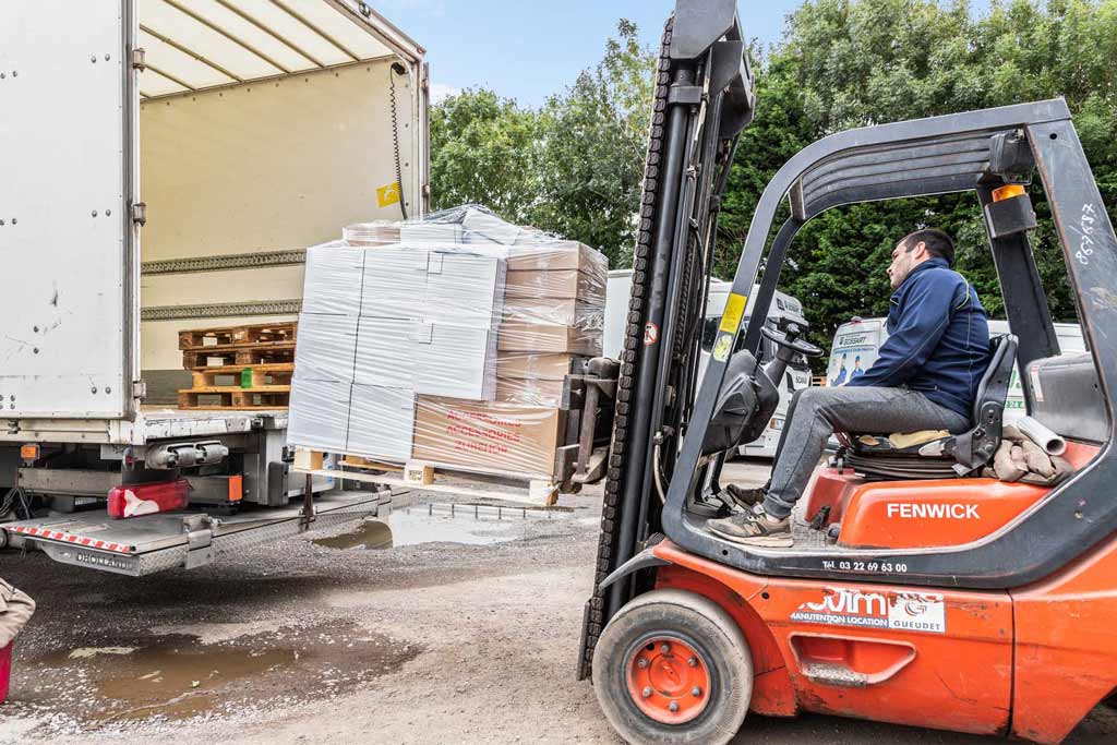 personnel de Grossart déménagement en train de charger un camion avec un manitou